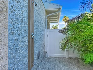 A gated area with a white door, a metal handle, and a small window. - Coastal Paradise- Brand new 4 bedroom with rooftop elevator (Holmes Beach)