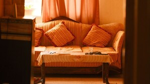 Um quarto aconchegante com um banco de madeira, um banco estofado e uma janela com cortinas.
