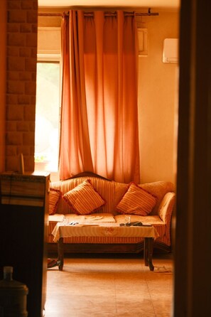 A cozy room with a wooden bench, a cushioned bench, and a window with curtains. - Cozy 1-bedroom apartment in adorable Amman with AC (Amman)