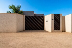 A gated entrance with a metal gate and a number sign indicating the location. - House in Guriri, Cabo Frio – Space & Convenience (Cabo Frio)