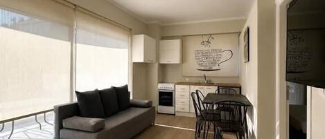 Un apartamento moderno con sala de estar, comedor y kitchenette.