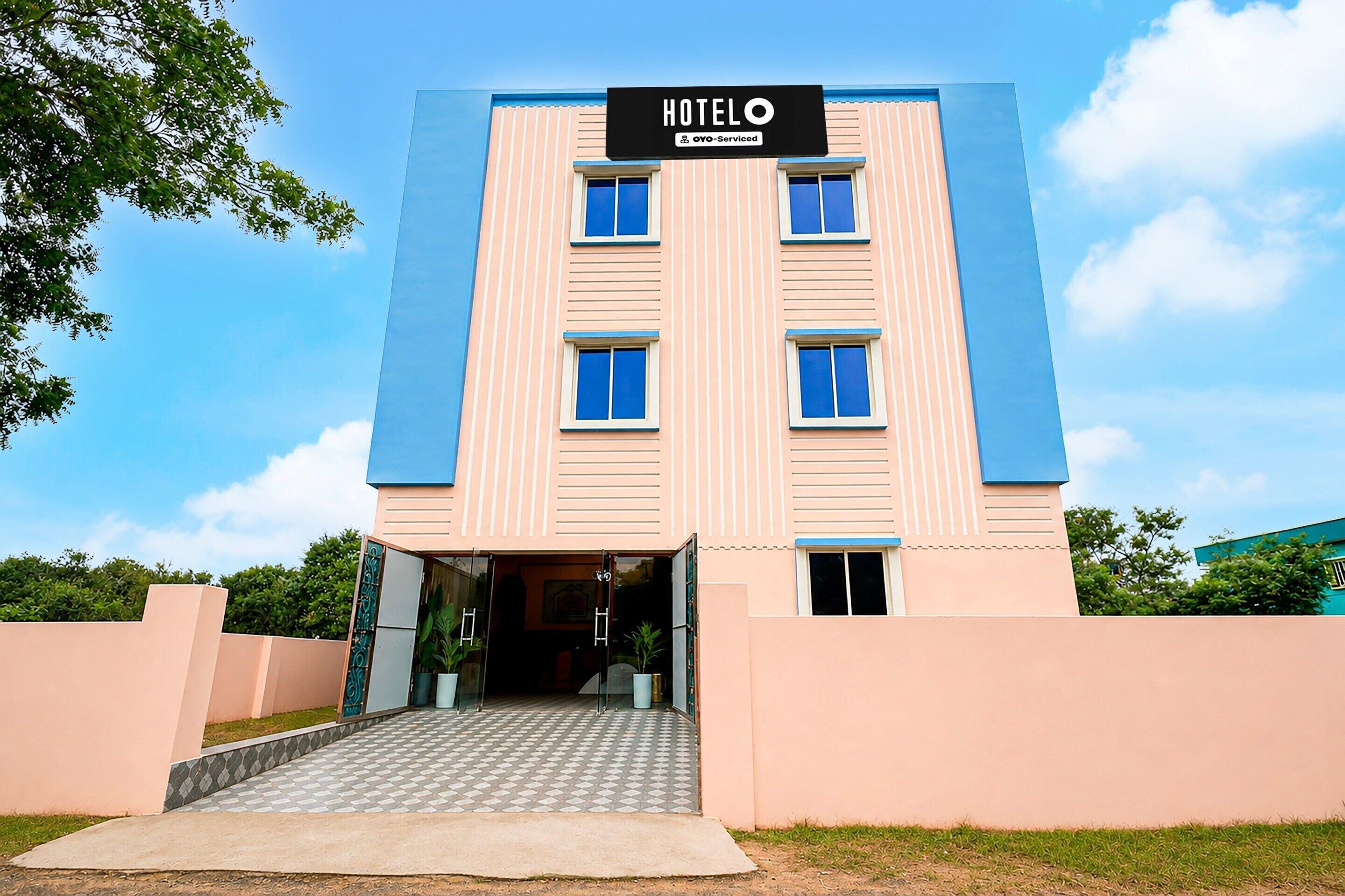 A hotel with a sign reading 'HOTEL' and 'OYO-Serviced' above the entrance.