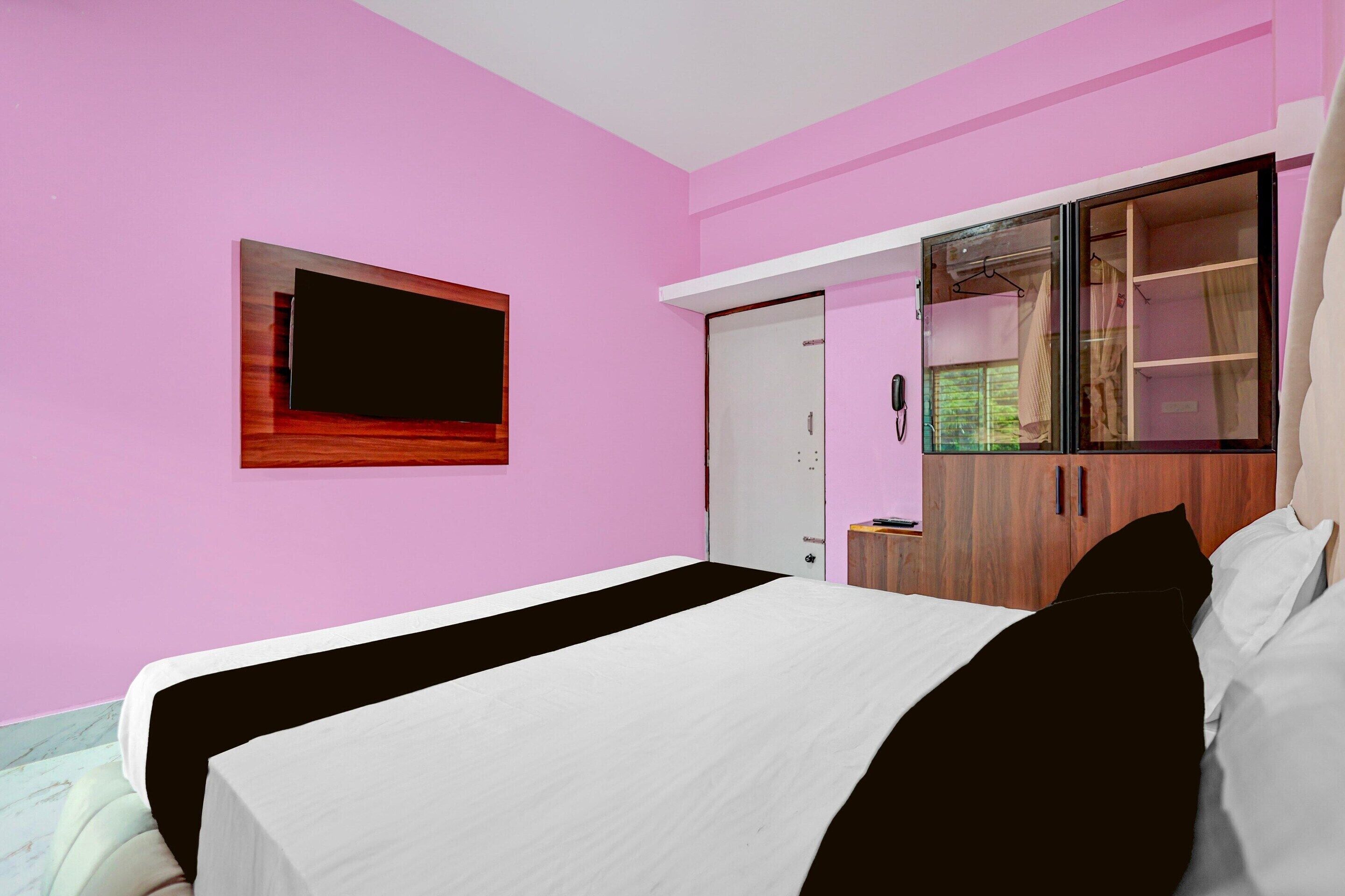 Una camera da letto con un letto, un armadio, uno specchio e una televisione.