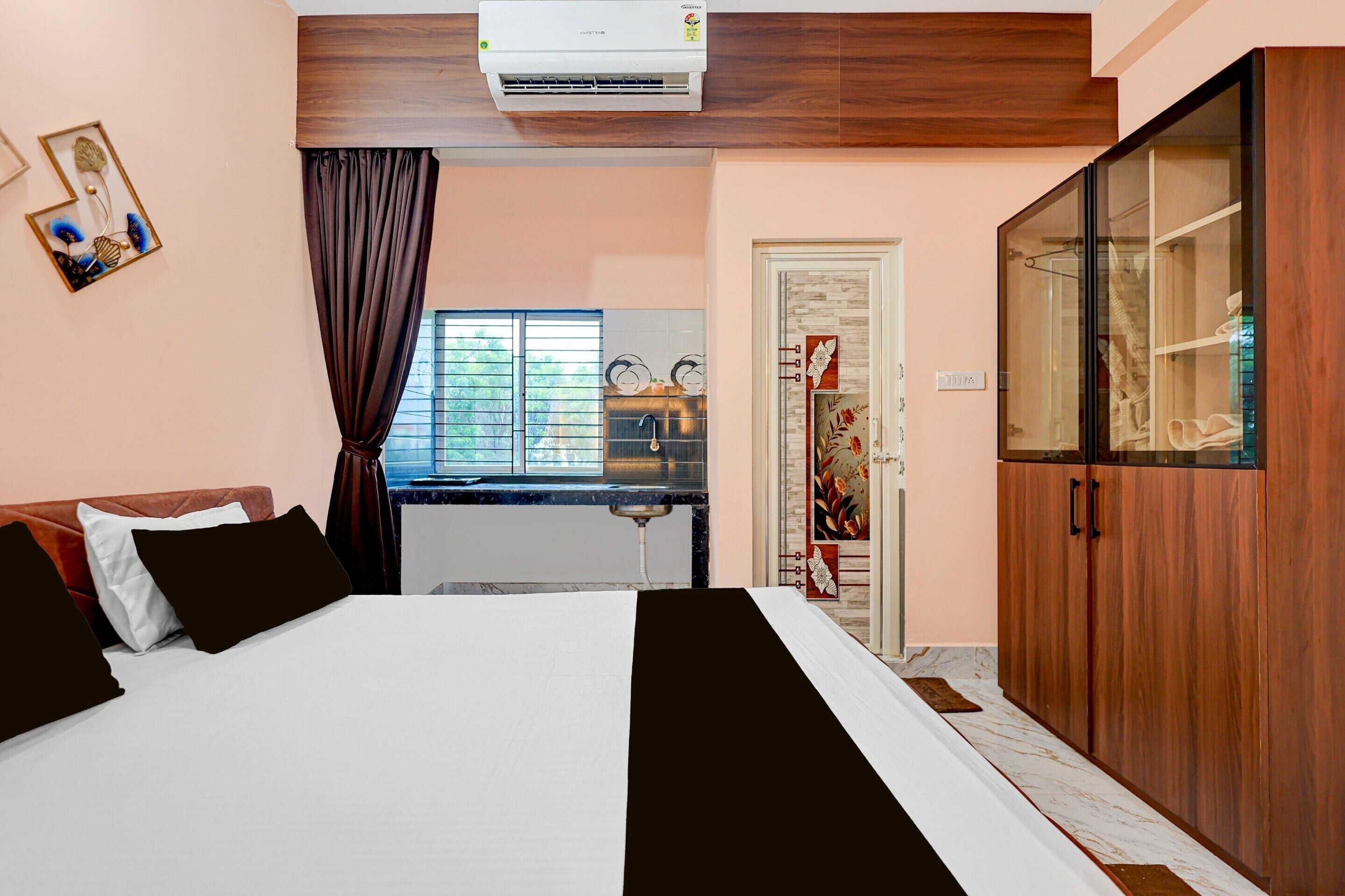 Une chambre à coucher comprenant un lit, une armoire, une fenêtre avec des rideaux et un appareil de climatisation.