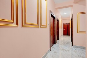 A corridor with marble flooring and doors with golden frames. - Classic Bhubaneswar New Station Road (Bhubaneshwar)