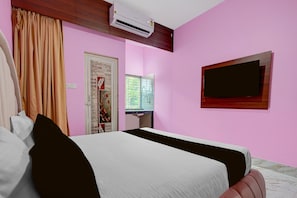 A hotel room with a bed, a television mounted on the wall, and a window with blinds. - Classic Bhubaneswar New Station Road (Bhubaneshwar)