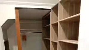 A walk-in closet with multiple shelves and hanging space.