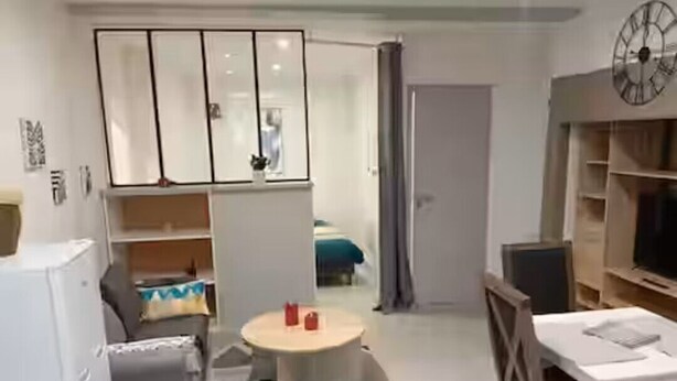 A modern room with a dining area, a small table, and a wardrobe with sliding doors.