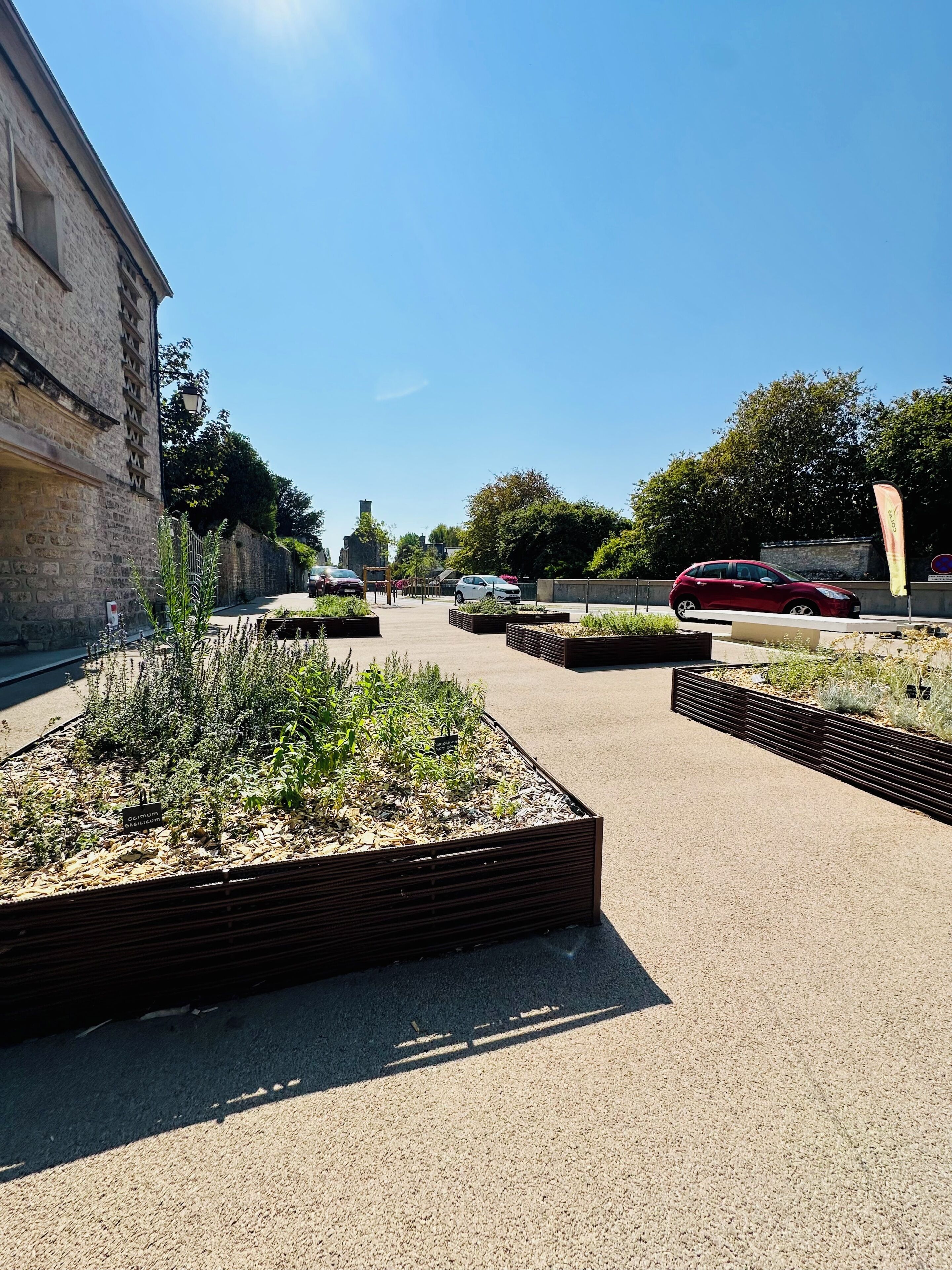 Un chemin pavé mène à un bâtiment dont la façade est en pierre.