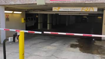 Entrada de estacionamiento con acceso restringido por altura y un código QR para ingresar.