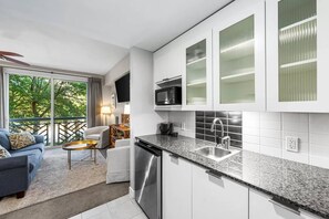 A modern kitchen with white cabinets, a stainless steel sink, and a microwave. - Luxury Baytowne Wharf- Bahia Breeze -Pool View (Miramar Beach)