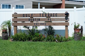 Ein hölzernes Schild mit der Aufschrift 'GULF TERRACE' und 'DESTIN FL gegründet 1973', das einen Ort kennzeichnet.
