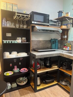 A compact kitchen with a microwave, toaster, and various utensils.