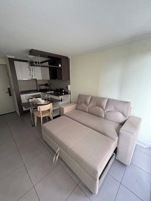 A compact living space with a sofa, a dining table, and a kitchenette. - "Fully equipped apartment with an elevated pool — Providencia, just steps away from everything" (Providencia)