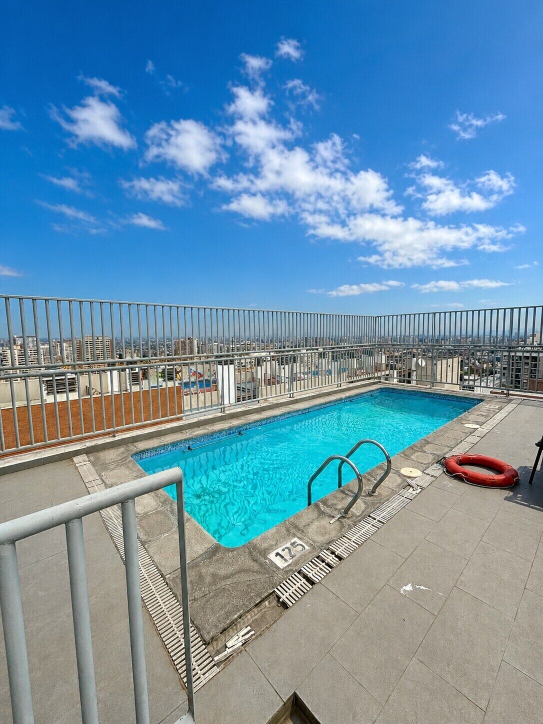 A rooftop pool with a clear blue sky in the background.