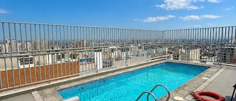 A rooftop pool with a clear blue sky in the background.