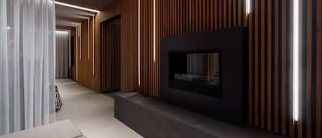 Un interior moderno con chimenea, paneles de madera y zona de estar.