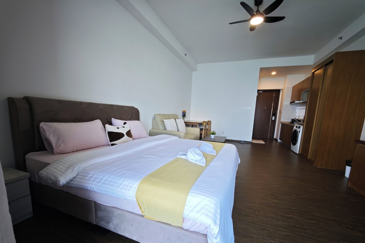 A hotel room with a bed, bedside table, and a ceiling fan.