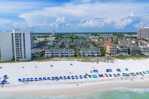 A coastal hotel with multiple buildings, a beach with umbrellas, and a clear view of the ocean. - Private Gulf Beach 3BR Townhome | Pools & Tennis (Destin)