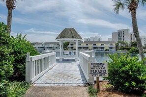 A wooden boardwalk leading to a gazebo with a sign indicating no swimming and no retailing access. - Modern Serenity - Destin Private Beach Access (Destin)