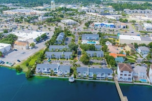 An aerial view of a coastal residential area with multiple-story buildings, a marina, and a water body. - Private Gulf Beach 3BR Townhome | Pools & Tennis (Destin)