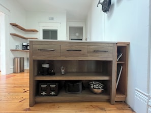 A kitchen with wooden cabinets, a coffee maker, and a kettle.