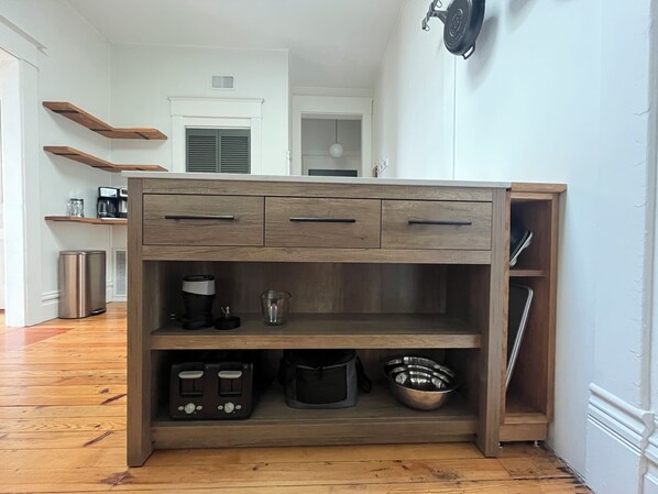 A kitchen with wooden cabinets, a coffee maker, and a kettle.