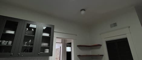A kitchen with a skylight, wooden cabinets, a dishwasher, and a coffee machine.