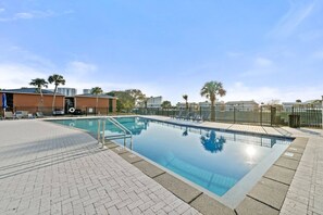 A rectangular swimming pool with a metal ladder, surrounded by a paved walkway and a fence. - Modern Memories - Peaceful Lakeside View (Destin)