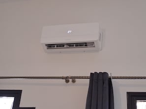 A white air conditioning unit mounted on a wall.