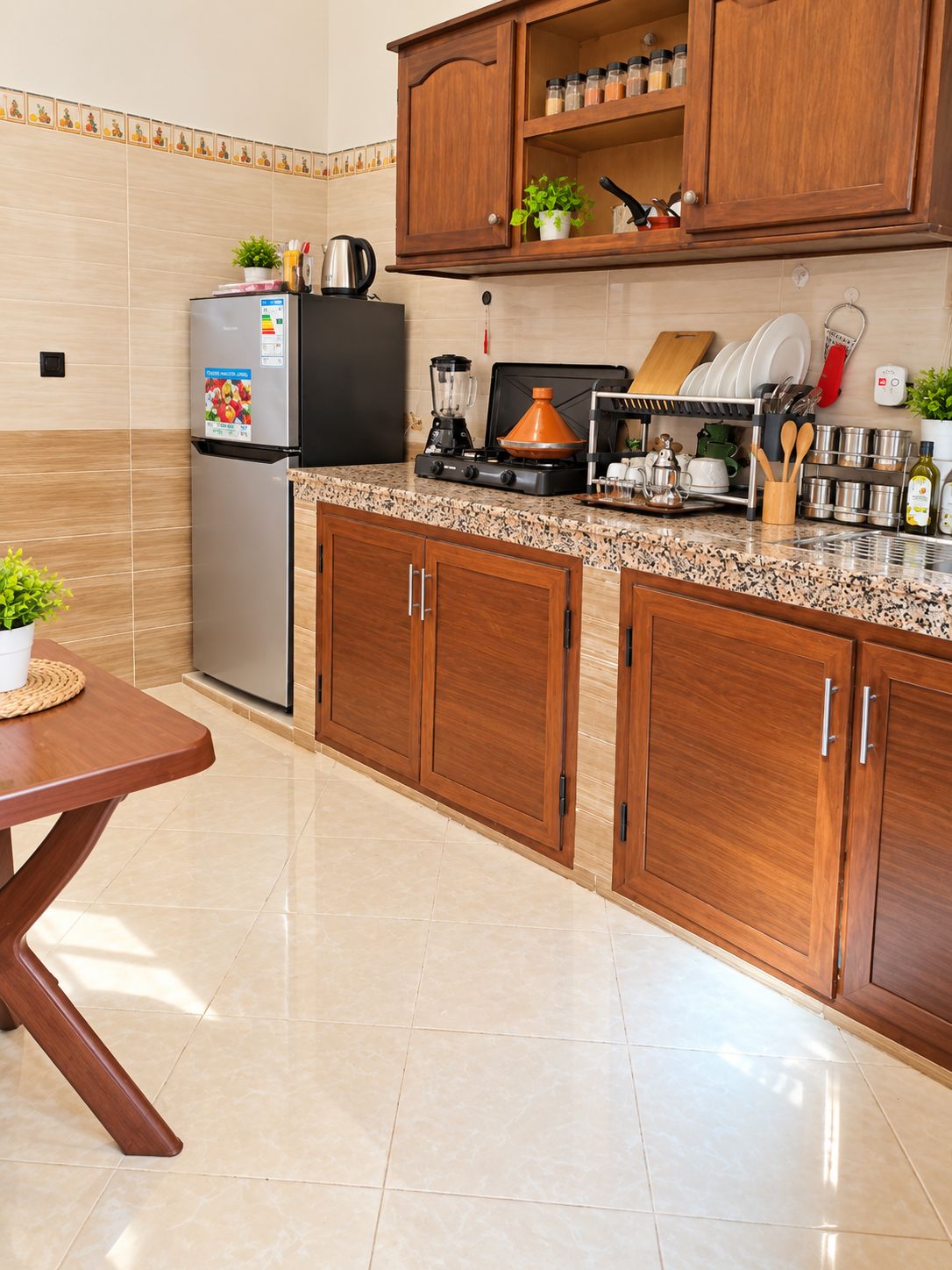 Una cocina con armarios de madera, un refrigerador de acero inoxidable, una estufa a gas y una cafetera.