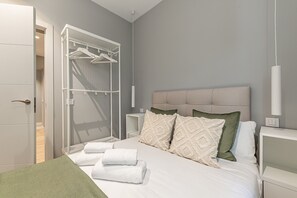 Un dormitorio moderno con una cama, armario empotrado y mesita de noche.