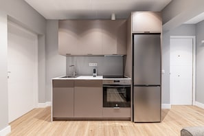 A modern kitchen with a built-in oven, a stainless steel refrigerator, and a double sink. - Waou Essence I Salamanca - Short-Term (Madrid)