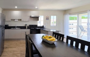 A modern kitchen with a dining area, a large window, and a view of the outside.