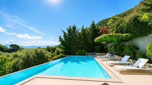 A rectangular swimming pool with clear blue water, surrounded by lounge chairs and a tiled deck. - Villa Oleana - Three Bedroom Villa, Sleeps 6 (Lefkada City)