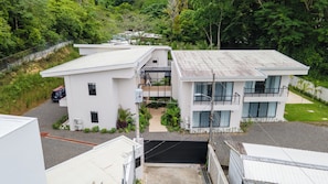 A modern two-story building with a flat roof, large windows, and a balcony. - Villa LaLa Land • 13 Suites • 2 Pools • Party Room (Jaco)