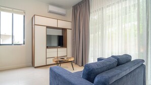 A modern living room with a sofa, a television, and a wardrobe. - Villa LaLa Land • 13 Suites • 2 Pools • Party Room (Jaco)