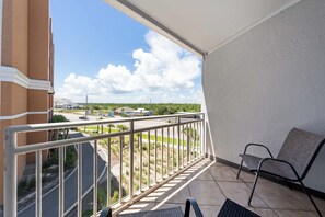 Ein Balkon mit Blick auf eine Straße, Gebäude und Grünflächen.