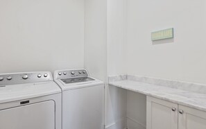A laundry area with a Maytag washer and dryer, a marble countertop, and a sign that reads 'BEACH LIFE'. - 🏖️4 Bikes | Community Pool | 630 Steps to Beach | Pirate’s Smile🏖️ (Inlet Beach)