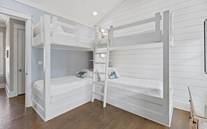 A room with bunk beds, a ladder, and a door leading to another room. - 🏖️4 Bikes | Community Pool | 630 Steps to Beach | Pirate’s Smile🏖️ (Inlet Beach)