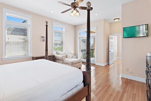A bedroom with a large bed, a ceiling fan, and a view of the outdoors through the windows. - 🏖️ The Mermaid | Private Pool • 6 Bikes • Walk to Beach 🌊 (Inlet Beach)
