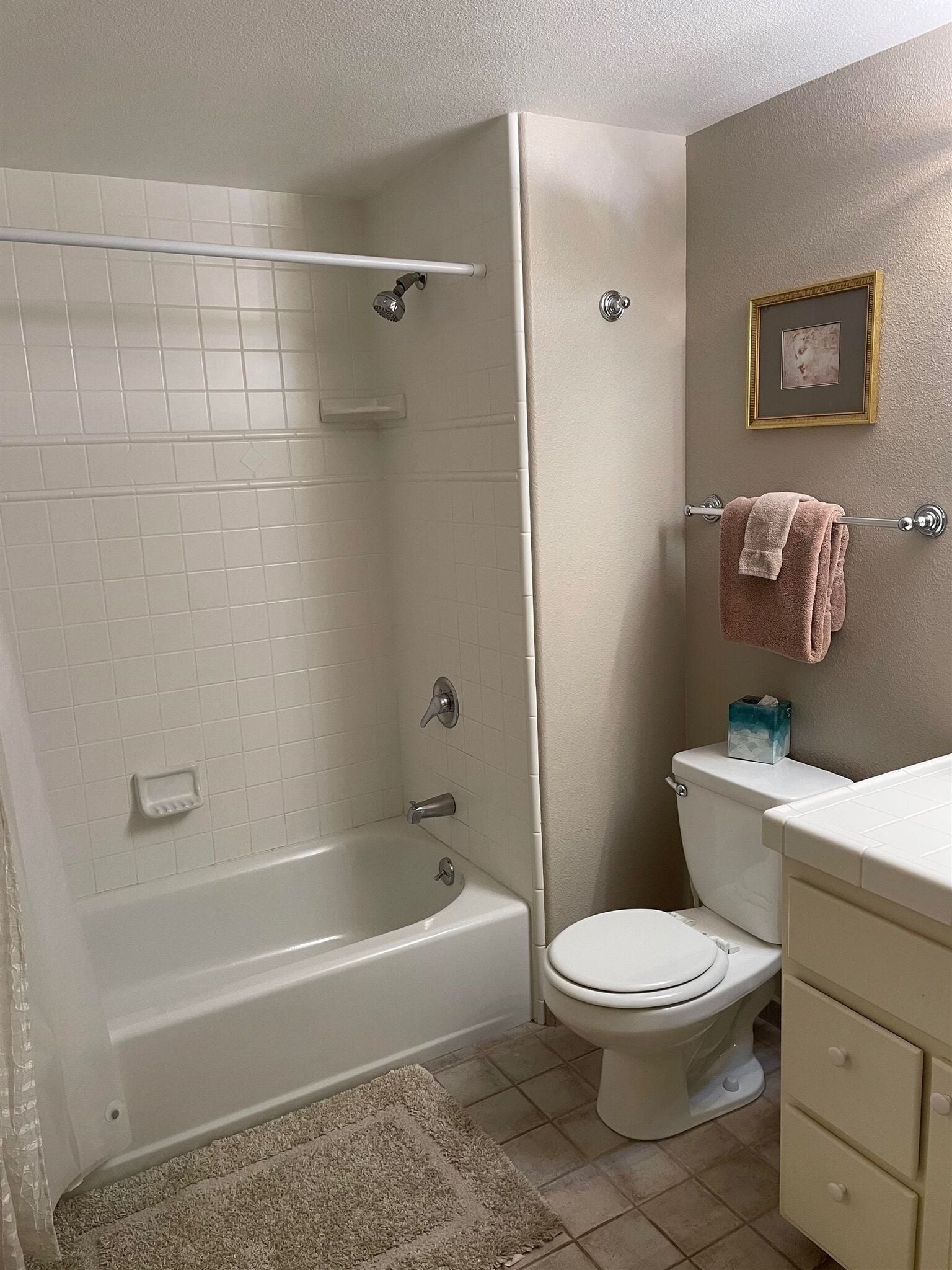 A bathroom with a bathtub, toilet, and a sink area.