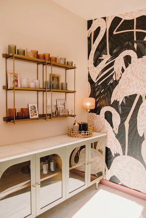 A room with a white console table, a wall-mounted shelf with decorative items, and a large abstract painting. - Welcome to The Sunnyside Pool House! Your Ultimate Coastal Escape (Sunnyside)