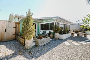 A residential property with a fenced yard, outdoor seating area, and potted plants. - Welcome to The Sunnyside Pool House! Your Ultimate Coastal Escape (Sunnyside)
