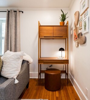 A compact living space with a bunk bed, a desk with a lamp, a potted plant, and a sofa with a blanket. - Midnight Inn, Garden B - Ground-Floor Historic Luxury on Monterey Square (Savannah)