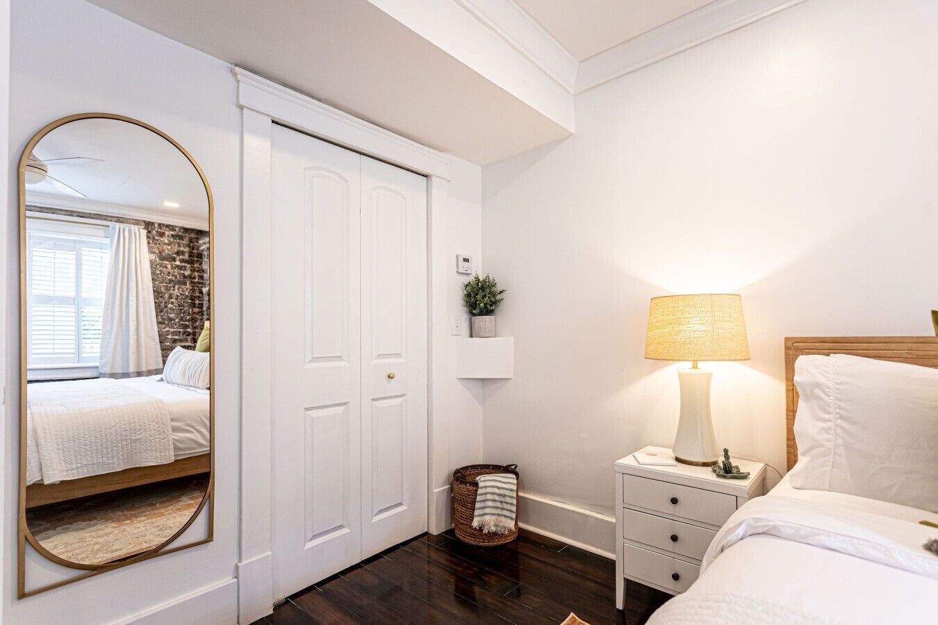 Un dormitorio con cama, mesita de noche, lámpara y armario.