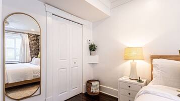 A bedroom with a bed, bedside table, lamp, and a wardrobe.