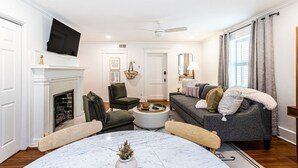 Ein Wohnzimmer mit Kamin, Fernseher, Sofa und Couchtisch.