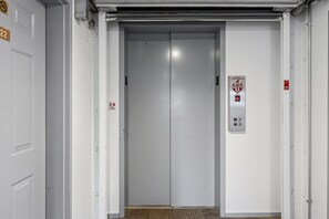 Geschlossene Elevatortür mit Brandschutztürschild und der Zahl 22 an der Wand.