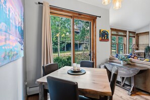Ein Essbereich mit Holztisch, Stühlen und Blick ins Freie.
